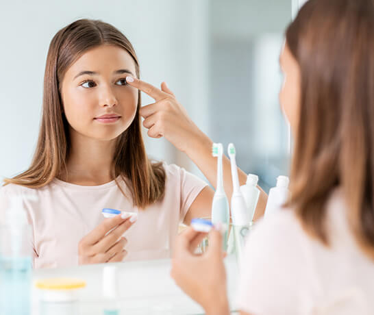 Girl putting on myopia management lenses